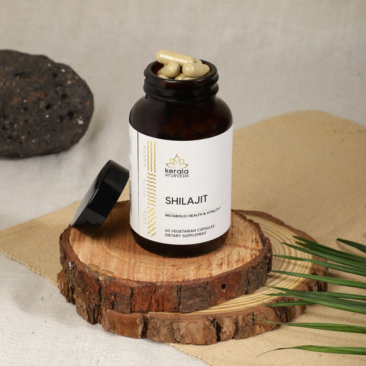 An open bottle of shilajit cappsules placed on small wooden plates beige background