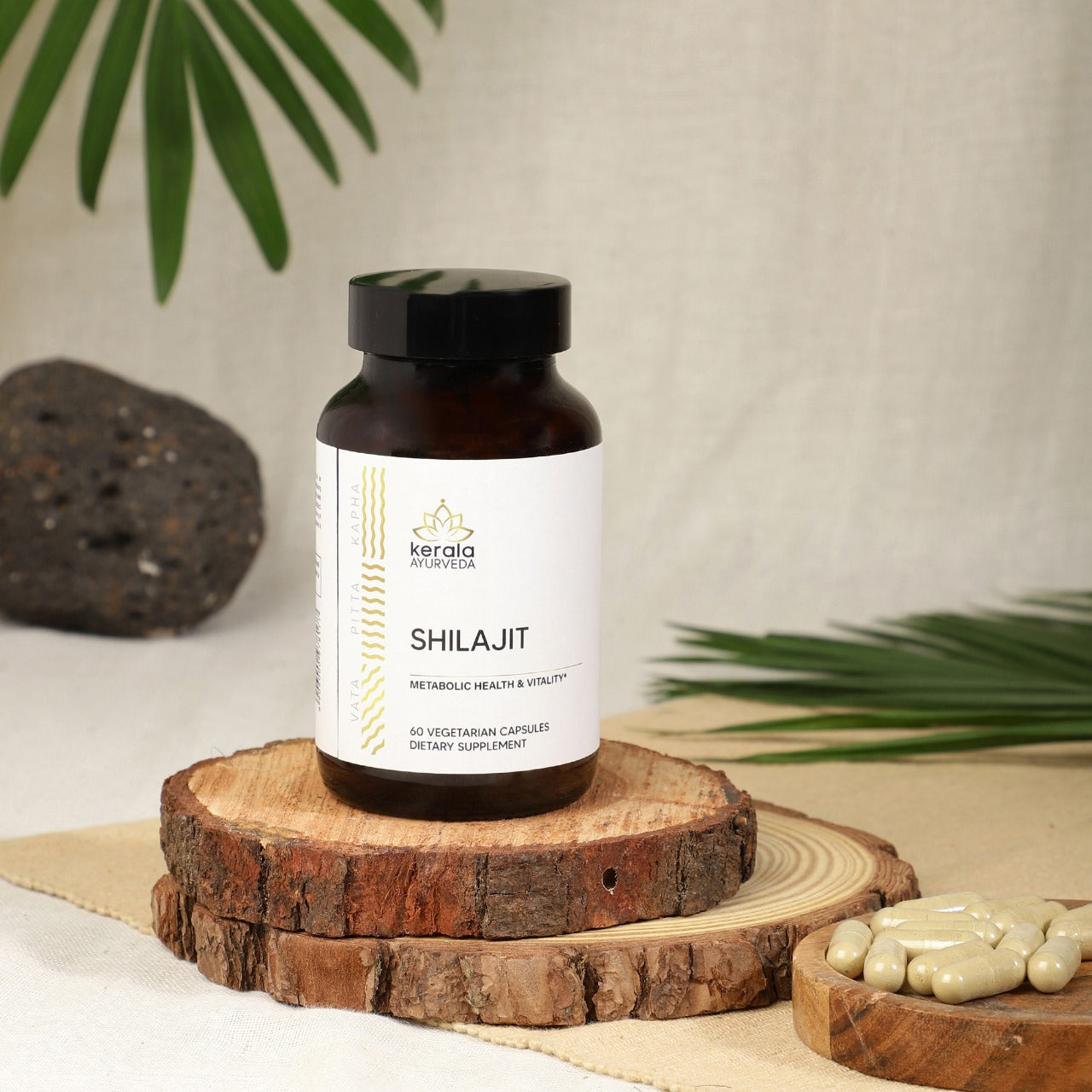 A bottle of shilajit cappsule bottle placed on small wooden plates beige background