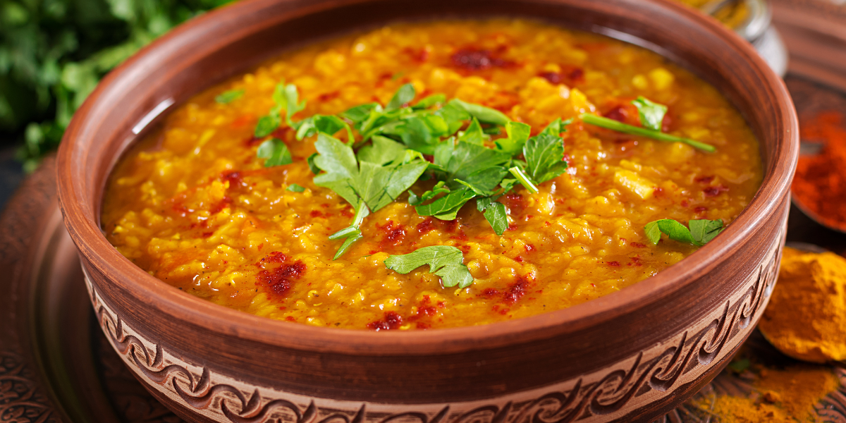 an image of kitchari in a clay pot, the image indicates the ingredients added in the kitchari which is consumed on kitchari cleanse diet