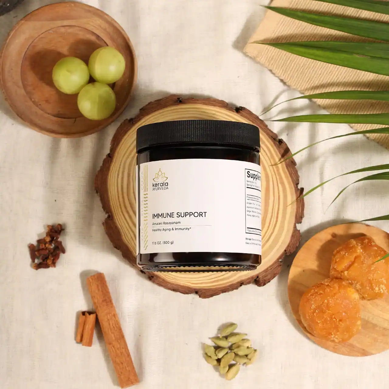 A jar of Kerala Ayurveda Immune Support, Amalaki Rasayana, lying on the wooden coaster with spices around.