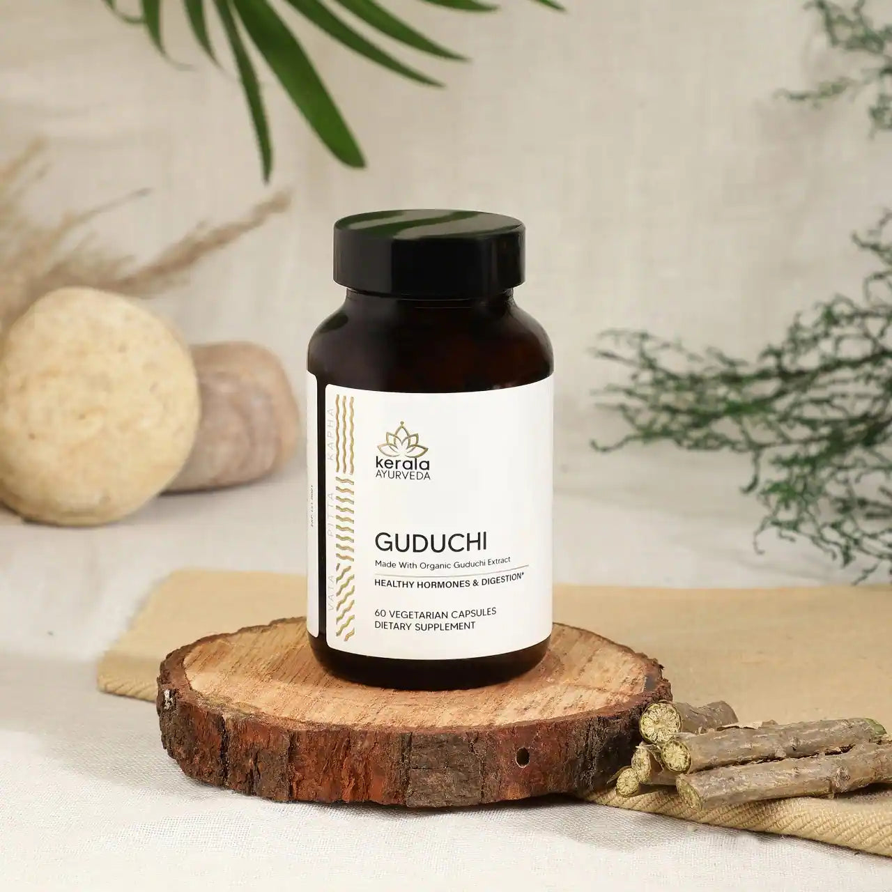 The  bottle of Kerala Ayurveda Guduchi capsules placed on the wooden coster with spices and beige background