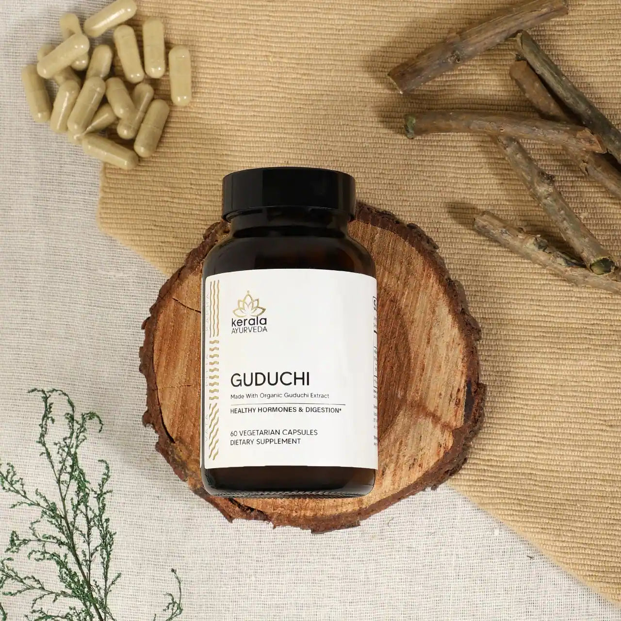 The  bottle of Kerala Ayurveda Guduchi capsules lying on the wooden coster with spices and capsules in the background