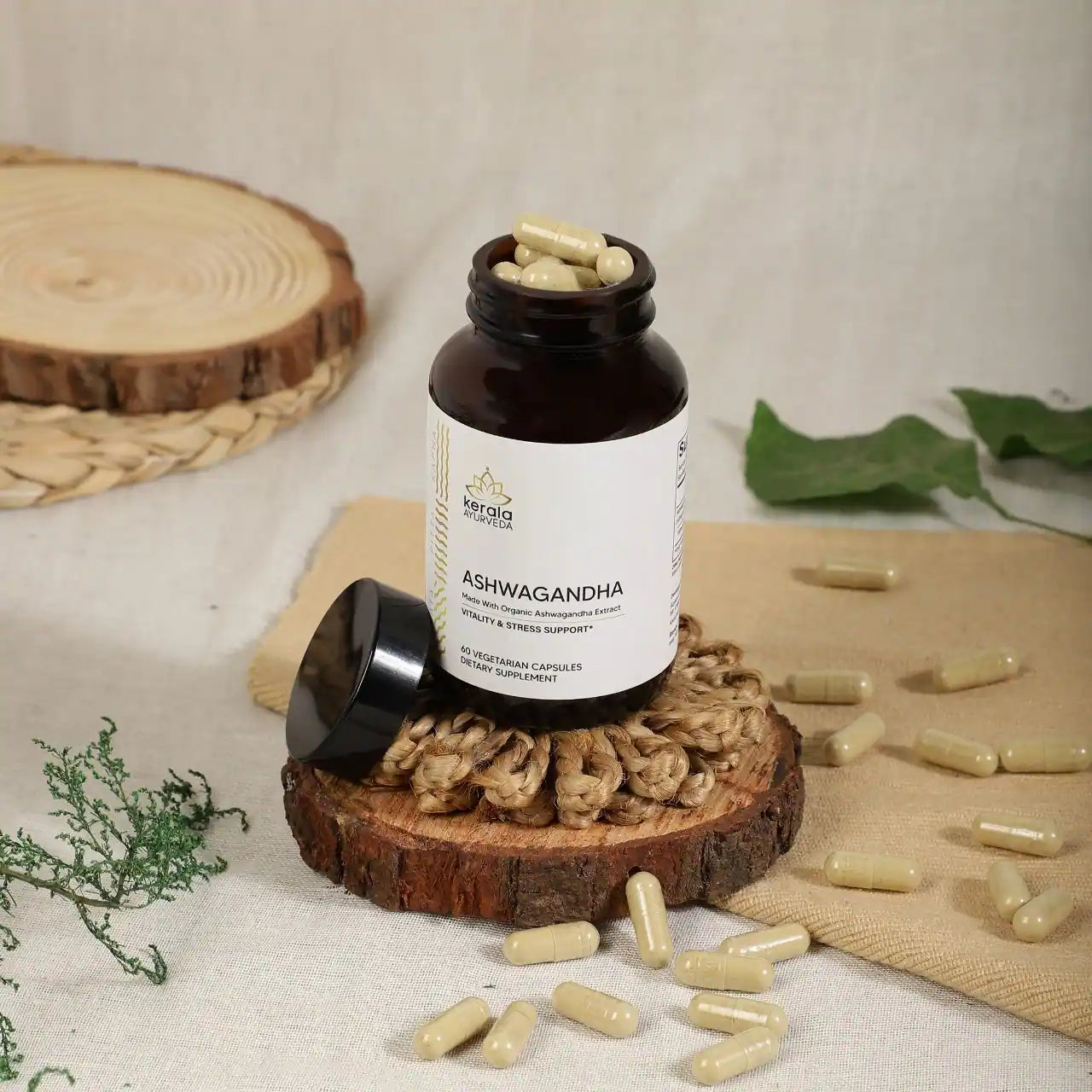 An open bottle of Kerala Ayurveda Ashwagandha dietary supplement with 60 capsules, labeled for vitality and stress support placed upon a wooden coster with beige background