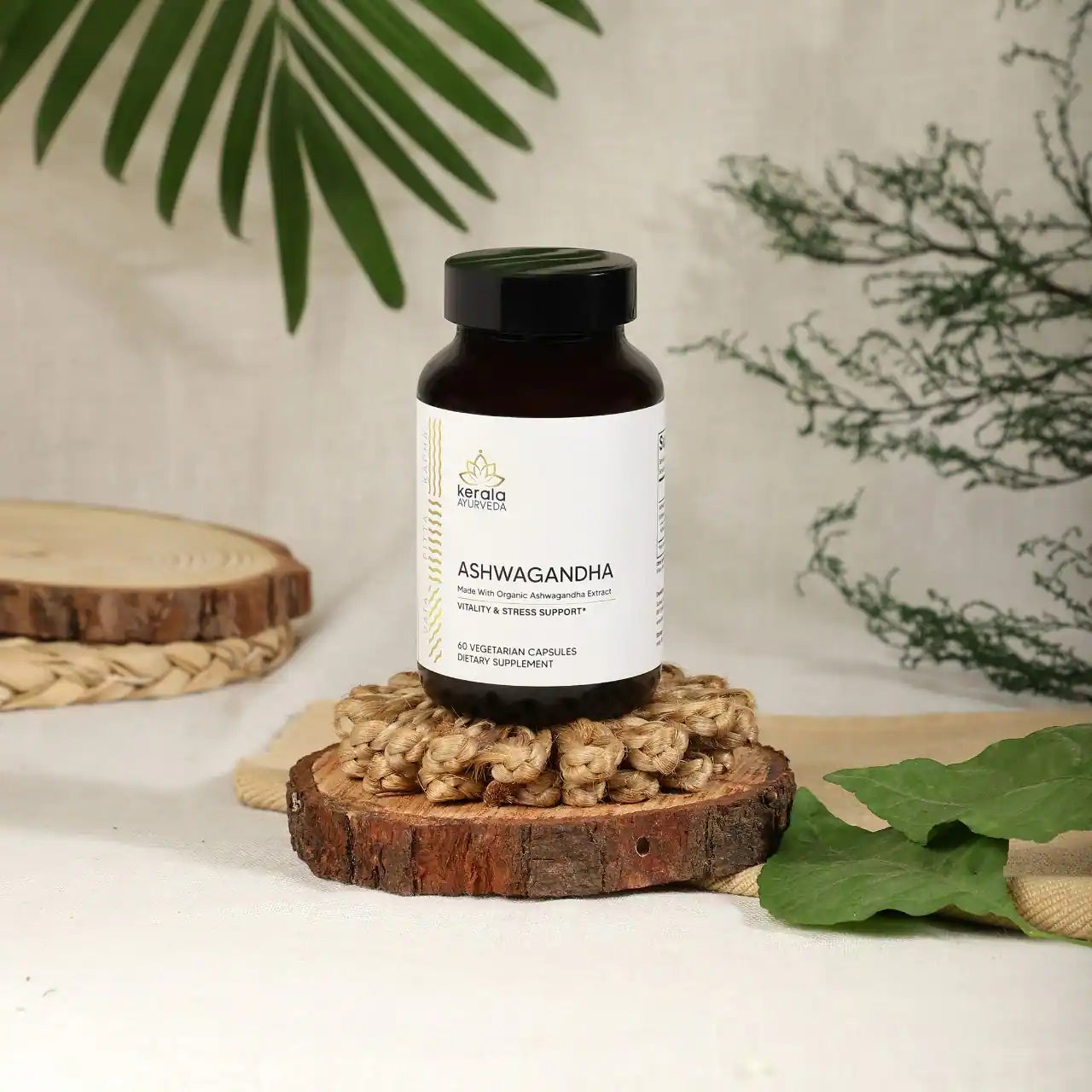 A bottle of Kerala Ayurveda Ashwagandha dietary supplement with 60 capsules, labeled for vitality and stress support placed upon a wooden coster with beige background
