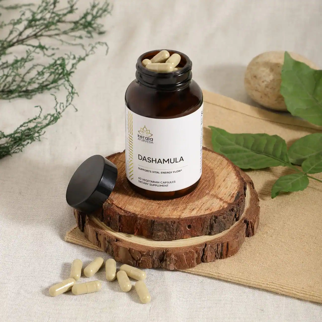 An open bottle of Kerala Ayurveda Dashamula capsules, with a white label displaying the product name and its purpose to support vital energy flow.