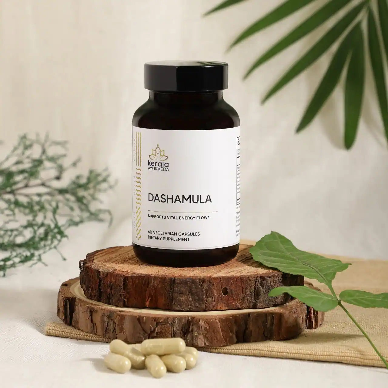 A bottle of Kerala Ayurveda Dashamula capsules, with a white label displaying the product name and its purpose to support vital energy flow with beige background