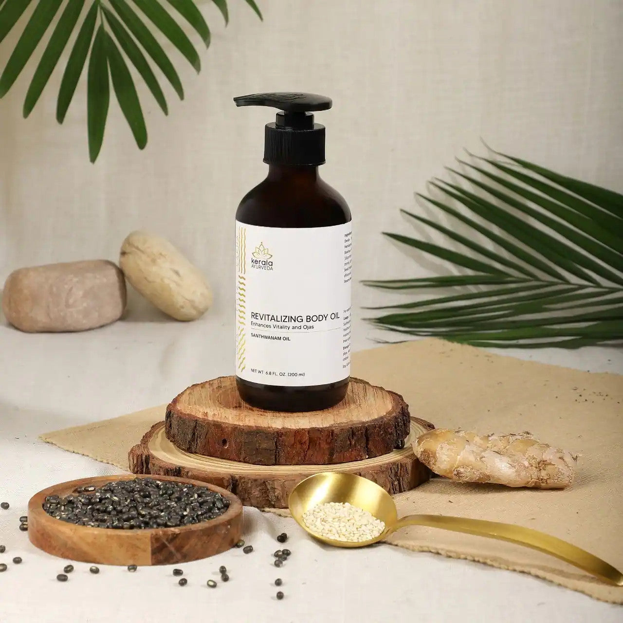 A bottle of Revitalizing Body Oil with a label that includes the brand name Kerala and the product name. The oil is in a clear amber bottle with a black pump with a beige background