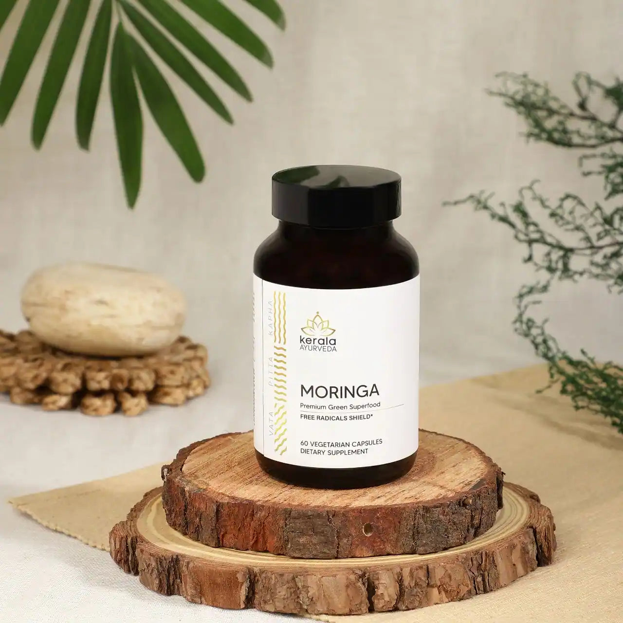 A bottle of Kerala Ayurveda Moringa dietary supplement with 60 vegetarian capsules places in the beige background 