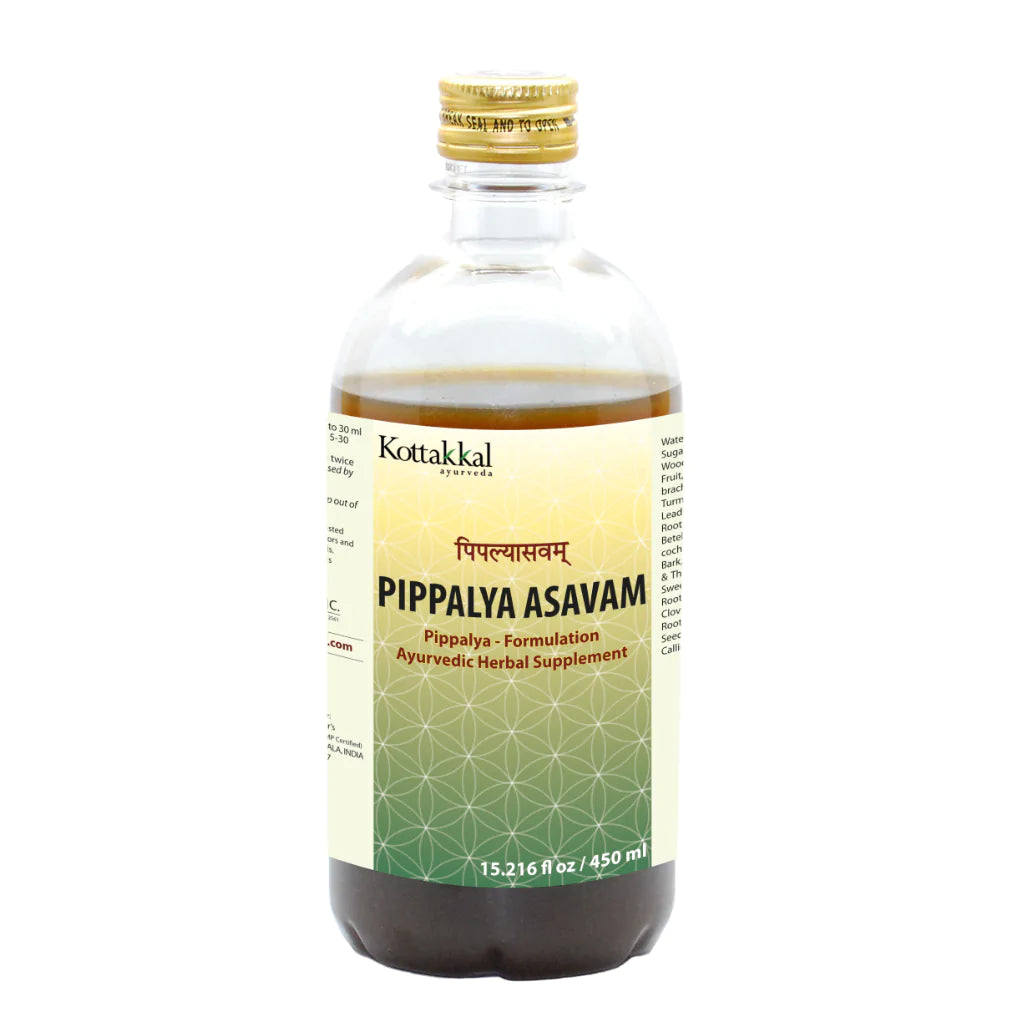 A bottle of KT Pippalya Asavam, a herbal supplement by Kottakkal, with label information in an indeterminate script.